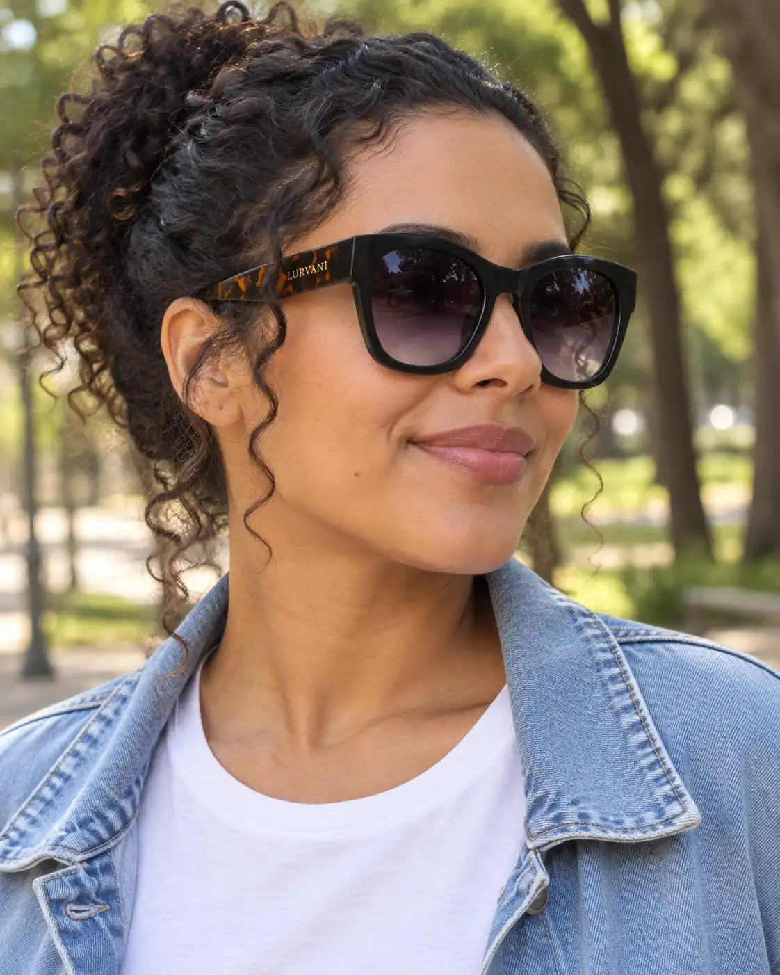 Mulher usando óculos de sol feminino quadrado preto modelo Ravenna LURVANI, em retrato de moda com enquadramento próximo.