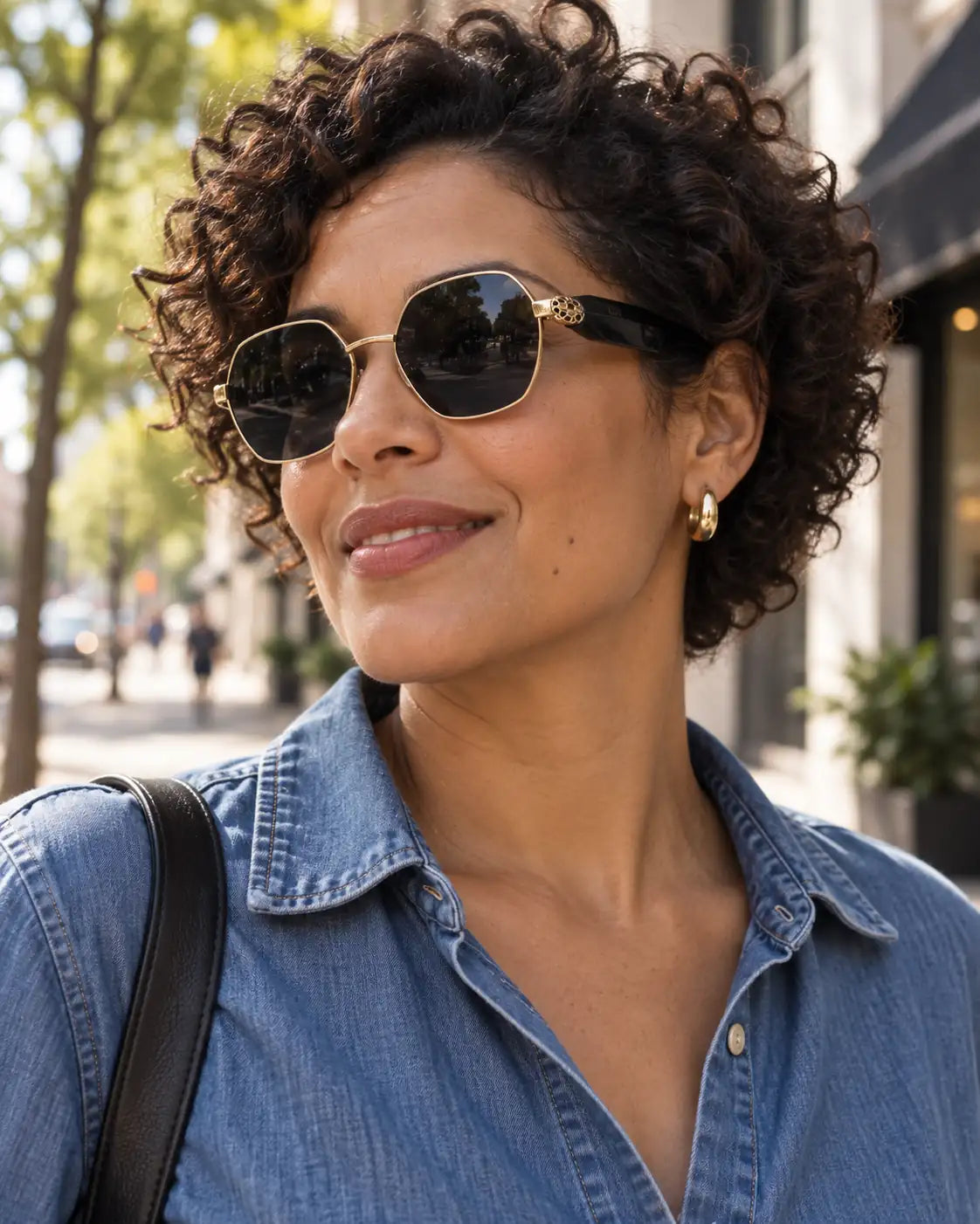 Mulher usando óculos de sol feminino octogonal dourado modelo Milano LURVANI, em retrato de moda com enquadramento próximo.