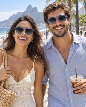 Homem e mulher usando óculos de sol unissex arredondado azul modelo Mônaco LURVANI, em retrato de moda com enquadramento próximo.