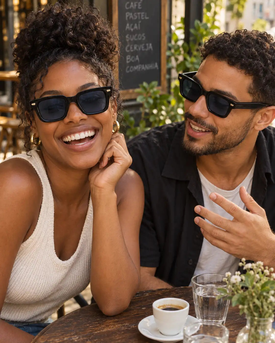 Homem e mulher usando óculos de sol unissex quadrado preto modelo Bergamo LURVANI, em retrato de moda com enquadramento próximo.